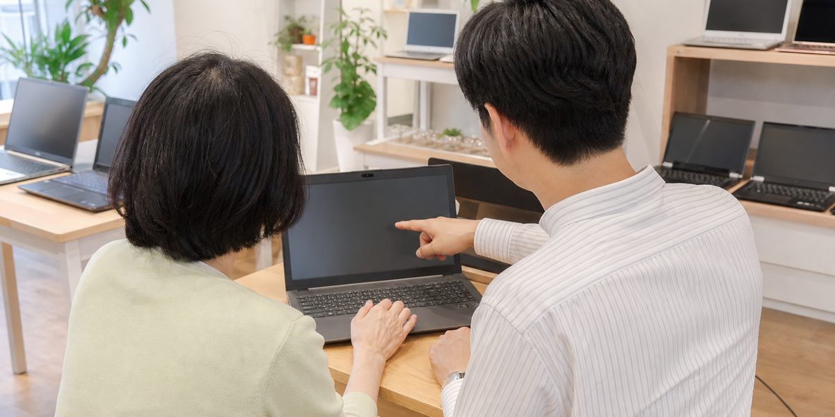 ご年配のお客様にノートパソコンの操作をご説明しているところ
